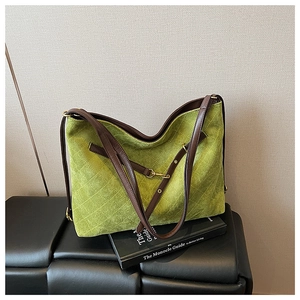 Detail of green quilted hobo bag featuring brown leather straps and metal hardware
