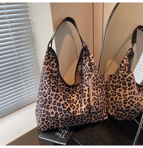 Detail of leopard print hobo bag showing faux leather strap and striped lining