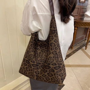 Gros plan du sac cabas en toile léopard avec bandoulière en cuir marron élégante