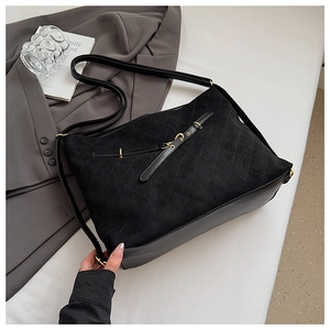 Close-up of quilted black backpack with gold buckle and mixed matte texture