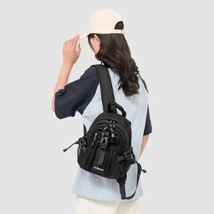 Detail view of mini black nylon backpack with multi-pocket design and adjustable straps