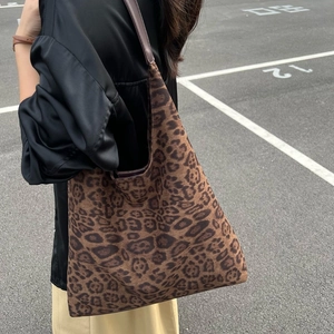 Sac seau léopard en daim synthétique avec bandoulière en cuir porté pour un look décontracté