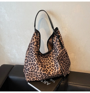 Detail view of large leopard print hobo bag with matching pouch and black leather handle