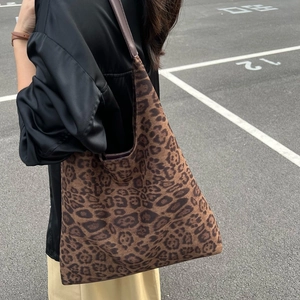 Vue détaillée du sac seau en daim à imprimé léopard avec large bandoulière sur modèle