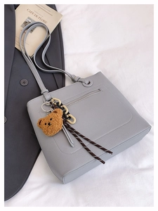 Detailed back view of light blue tote with zipper pocket and cute brown bear charm