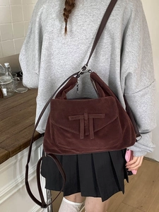 Retro dark brown matte leather tote bag with shoulder strap in a cozy indoor setting