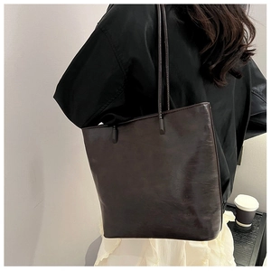 Minimalist dark leather tote bag shown on model highlighting size and daily style