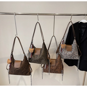 Détail de quatre sacs cabas à imprimé léopard avec garniture en cuir et pendentif ours