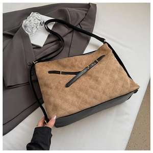 Detail of diamond-quilted brown suede and black leather stitching with gold hardware