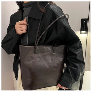 Detailed side view of deep brown faux leather tote bag with vintage wrinkled texture
