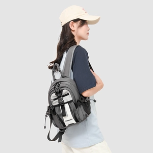 Close-up of a mini outdoor backpack showing grey texture and adjustable buckle straps