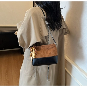 Detail of vintage quilted crossbody bag with brown suede and black leather finish