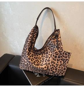 Close-up of leopard print hobo bag set with matching zipper pouch and brown strap