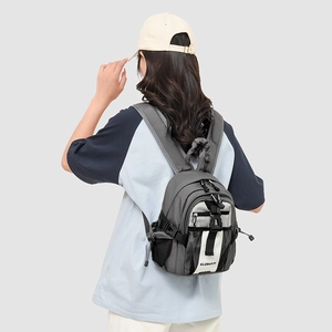 Rear view of a minimalist grey mini backpack with white panels and adjustable straps