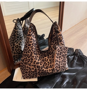 Detail of leopard print tote bag with a small matching pouch and brown leather handles