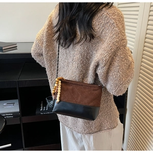 Detailed side view of vintage quilted suede crossbody bag with elegant beaded charm strap
