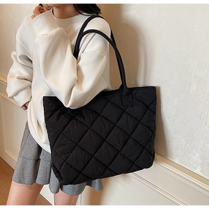 Gros plan d'un grand sac cabas noir matelassé avec motif classique à losanges doux