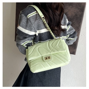 Detail of mint green quilted bag with wavy stitching and gold twist lock closure