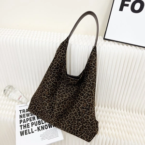 Détail du sac seau en daim à imprimé léopard avec bandoulière en cuir marron