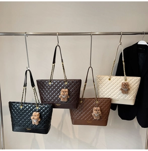 Détail de sacs cabas matelassés en noir, café, caramel et crème avec bandoulières en chaîne