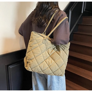 Détail d'un grand sac cabas matelassé vert kaki avec coutures en losanges et larges anses