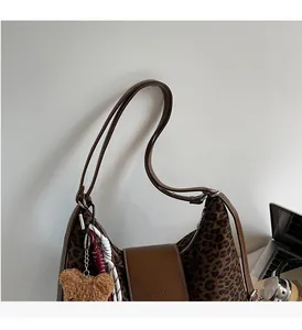 Détail du sac cabas léopard avec rabat en cuir et breloque ours en peluche