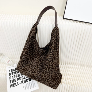 Détail du sac fourre-tout à imprimé léopard en similicuir suédé marron et anses en cuir