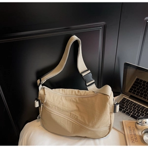 Detail of beige nylon crossbody bag with multi-zipper pockets and buckle strap for commute