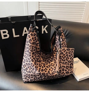 Detail of leopard print tote bag with matching zippered pouch on black leather sofa