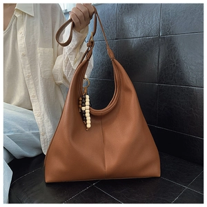 Detail of brown lychee texture hobo bag with unique tricolor wooden bead pendant charm