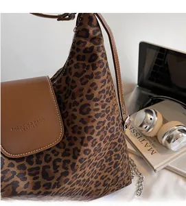 Détail du sac cabas léopard avec rabat en cuir marron et chaîne argentée