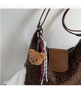 Détail du pendentif ours en peluche et cordes tressées sur sac à main léopard