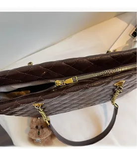 Détail macro de la texture en cuir matelassé et fermeture éclair dorée du sac cabas