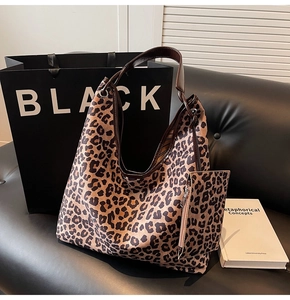 Close-up of leopard print tote bag with leather strap and matching small zipper pouch