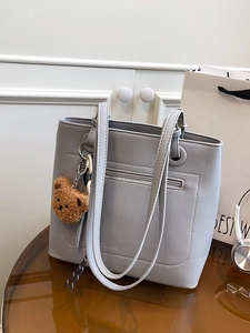 Grey lychee leather tote bag with front zipper and plush bear charm for daily commute