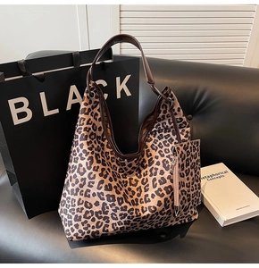 Detailed view of leopard print canvas hobo tote bag with brown leather handle and pouch
