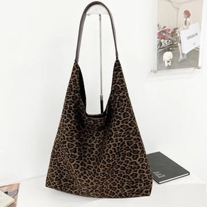 Détail du sac fourre-tout à motif léopard avec des anses en cuir marron sur support