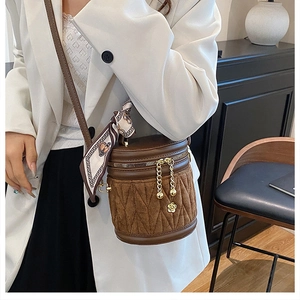 Detail der braunen Vintage-Eimertasche mit gestepptem Wildleder und Seidenschal-Griff