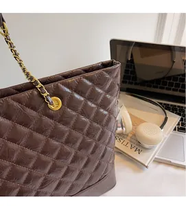 Détail du sac cabas matelassé marron foncé avec élégante bandoulière en chaîne dorée