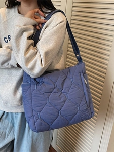 Quilted blue crossbody tote bag made of puffer nylon fabric with adjustable wide strap