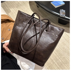 Detailed view of the dark brown tote bag showing vintage pleated texture and PU leather finish