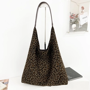 Détail du grand sac cabas en daim à imprimé léopard avec des anses en cuir marron foncé
