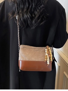 Retro quilted bucket bag in khaki suede and brown leather with chain strap on model