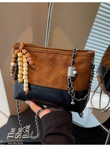 Vintage quilted crossbody bucket bag with brown suede contrast and wood bead tassel