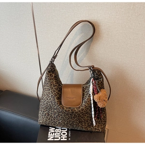 Détail du sac hobo léopard avec bandoulière en cuir et charmant porte-clés ours