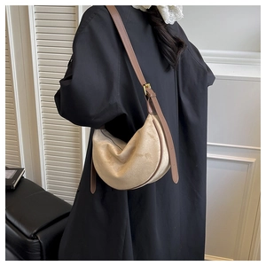Detail der beigen hobo-tasche aus wildleder mit brauner lederpaspel und goldschnalle