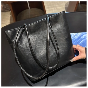 Top view of large black tote bag featuring textured leather and slim double shoulder straps