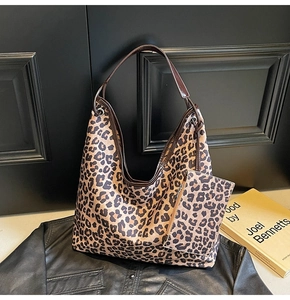 Close-up of leopard print tote bag set with matching pouch on vintage dark background