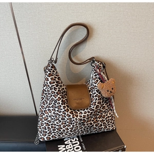 Détail du sac hobo à imprimé léopard avec bandoulière en cuir et charm ours en peluche