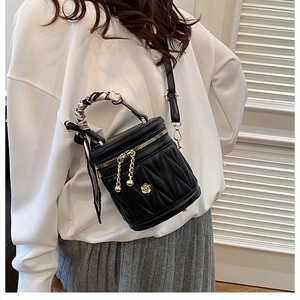 Schicke gesteppte Leder-Beuteltasche mit Kamelien-Logo am Modell im Alltagsoutfit